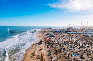 A large crowd gathered at a beach on a sunny day.