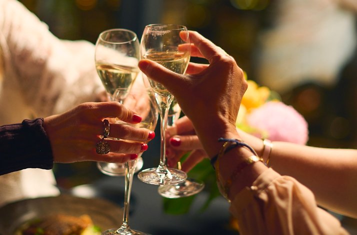 Close-up of guests clinking champagne glasses at Eureka 89.