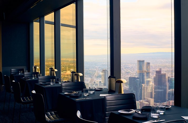Dining area at Eureka 89 restaurant with floor-to-ceiling windows overlooking Melbourne's Southbank skyline.