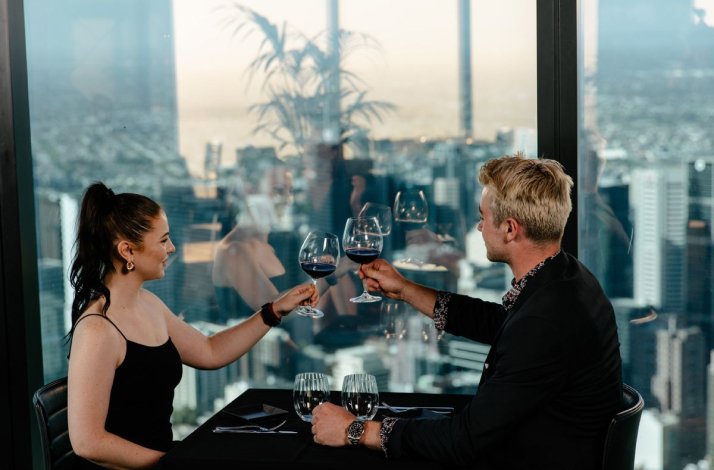 A couple dressing elegant sharing two wine glasses on a fine lunch at Eureka 89 