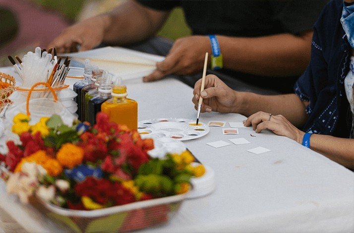 Individuals taking part in a watercolor painting session at Wonderfruit 2025.
