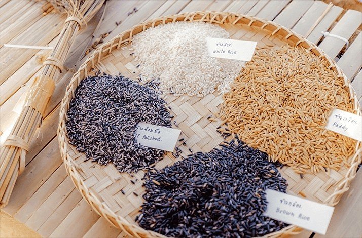 A variety of rice grains on a traditional woven tray
