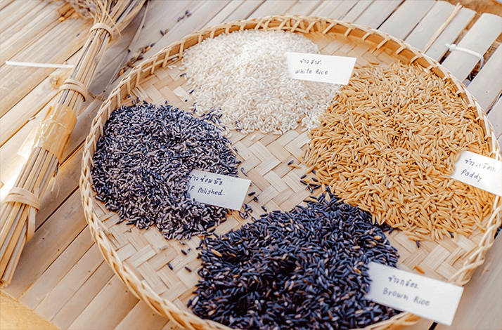 A variety of rice grains on a traditional woven tray