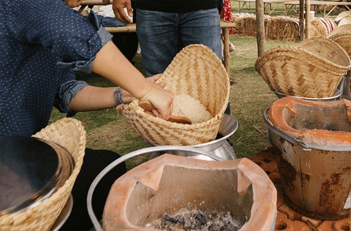 Someone preparing a traditional Thai dish, a type of sticky rice