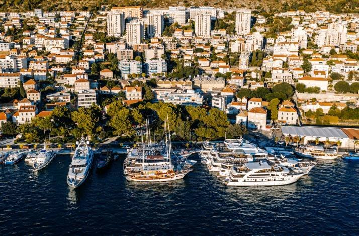 An aerial photograph captures a marina in Dubrovnik, Croatia with a harbor filled with boats.