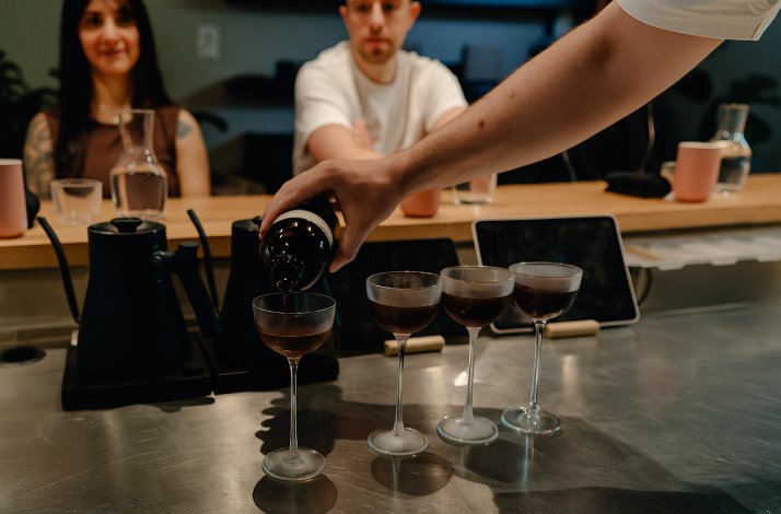A barista preparing a sofisticated brewing with wine and coffee