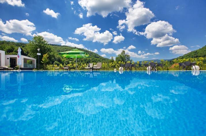 Stunning outdoor pool reflecting blue skies and mountains, perfect for relaxation.