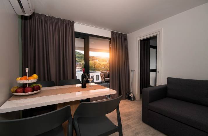 Cozy living area with dining space, mountain views, and sunset-lit ambience indoors.