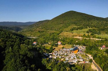 Aerial view of a lush mountain landscape with scattered buildings nestled among the greenery.