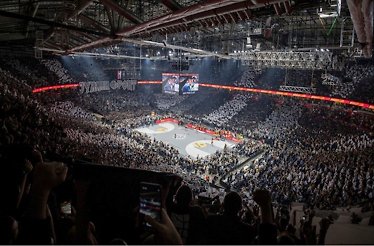 Packed arena with Partizan fans displaying vibrant cheers during a basketball game
