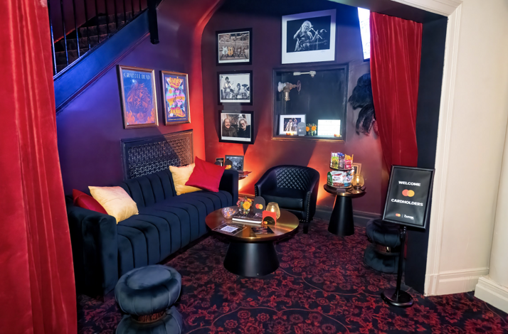The private Stage Lounge at The Capitol Theatre, featuring red ambience lighting and curated rock 'n' roll photography.