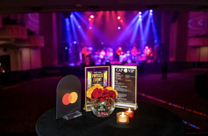 A table with a Mastercard logo and an excellent view of The Capitol Theatre stage from Cap Stage Lounge. 