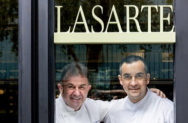 Chefs Paolo Casagrande and Martín Berasategui standing by the window at Lasarte Restaurant in Barcelona, Spain.