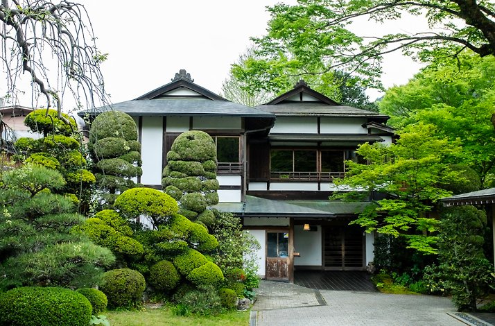 Traditional Japanese building surrounded by manicured greenery.