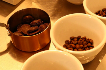 Coffee beans are being ground in a sleek, modern coffee grinder, producing a fine, aromatic coffee powder.