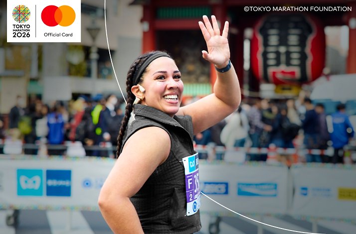 Woman waving at the crowd while running Tokyo Marathon. © Tokyo Marathon Foundation