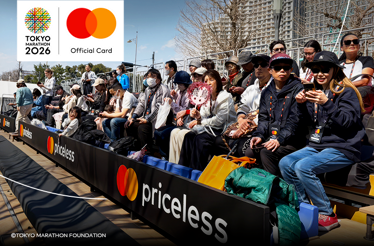 Tokyo Marathon spectators sitting in the stands with priceless branding and watching the race. © Tokyo Marathon Foundation