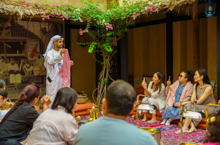 Cultural demonstration of Emirati attire and traditions for an engaged audience at House 26