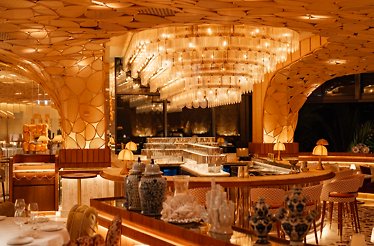 The elegant interiors of Mediterranean and Japanese Restaurant KIRA, featuring gold accents and hand-painted blue ornaments.