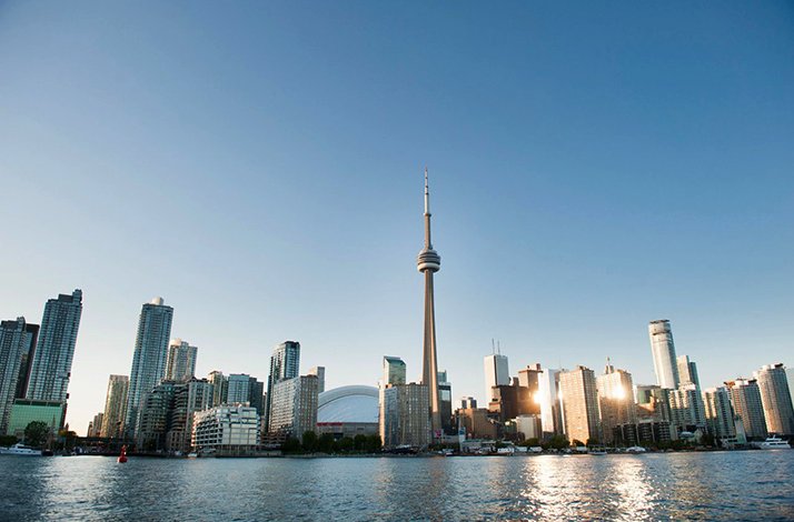 Toronto skyline from across the water, showcasing the city's modern architecture under a clear, bright sky