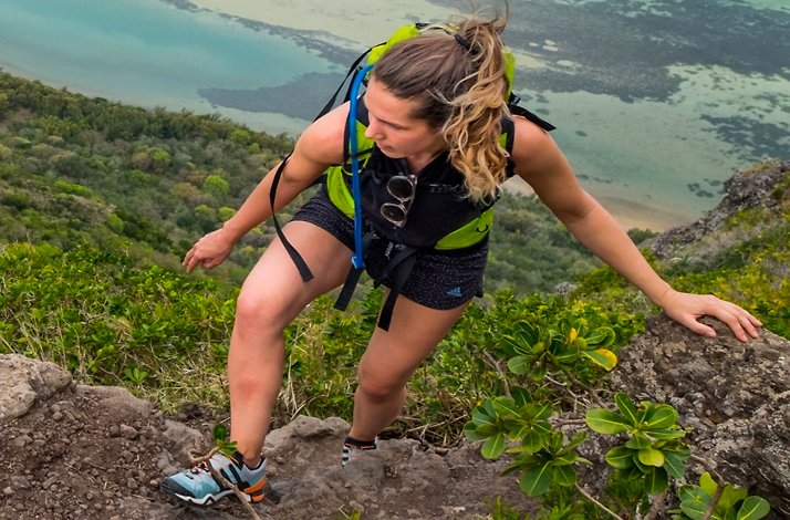 A young woman on a hike up Le Morne Brabant, a UNESCO World Heritage site known for its dramatic cliffs and sweeping ocean views.