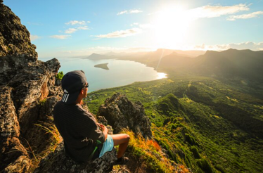 A man having ocean view from the Le Morne Brabant cliff.
