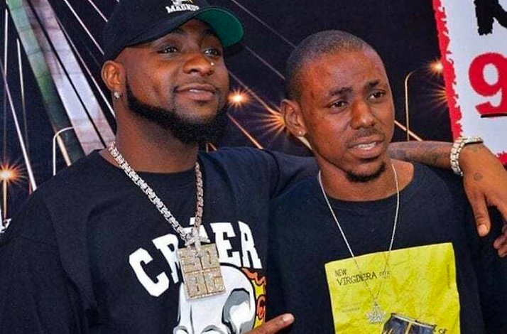 A candid moment between Nigerian music star Davido posing for a photograph with a fan, at an event.