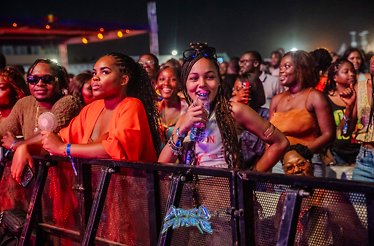 A group of crowds are enjoying at the AfroFuture concert, while standing behind a security barrier in El Wak Stadium.