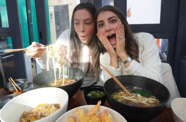 Sistersnacking sisters tasting ramen.