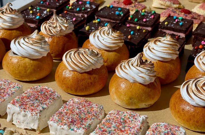 A table showcasing an assortment of pastries and desserts, including cakes, tarts, and cookies, beautifully arranged.