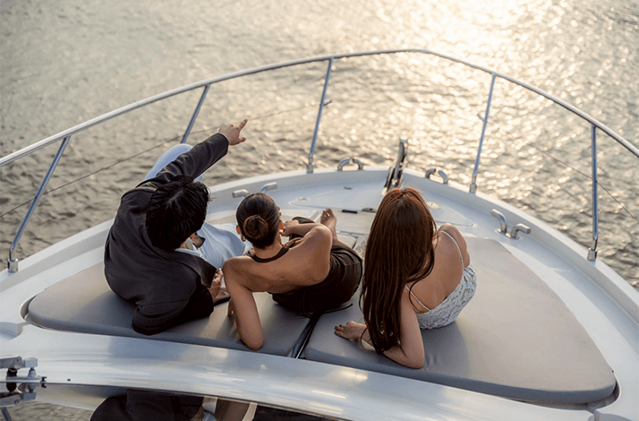 Three people sitting in the front board of a Yacht