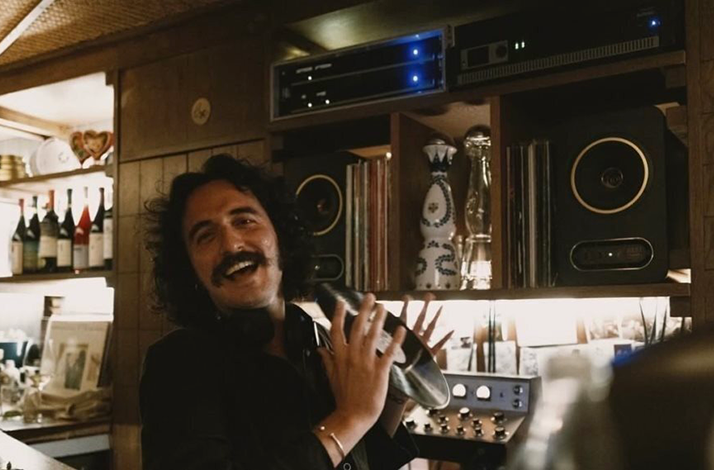 Panos Dimitropoulos holding a vinyl record and smiling 