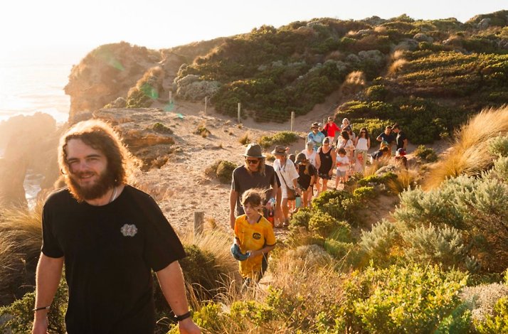 People trekking along a scenic coastal path with ocean views.