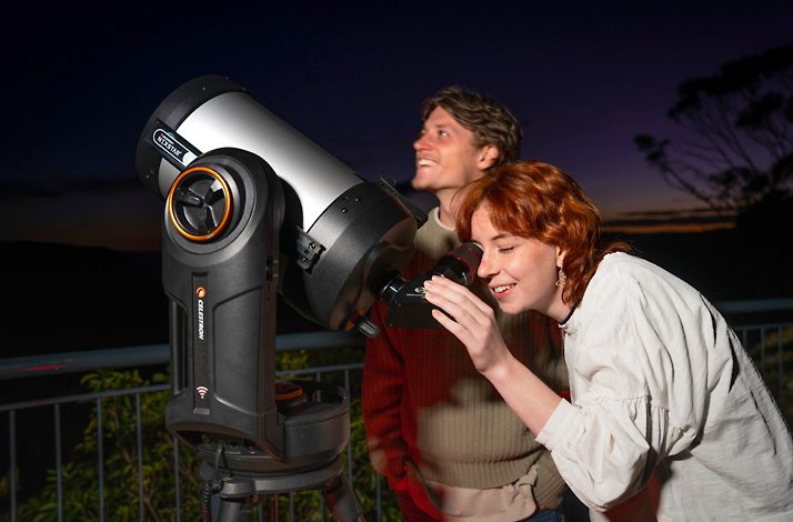 Two people using a Celestron NexStar telescope for stargazing in the Blue Mountains.