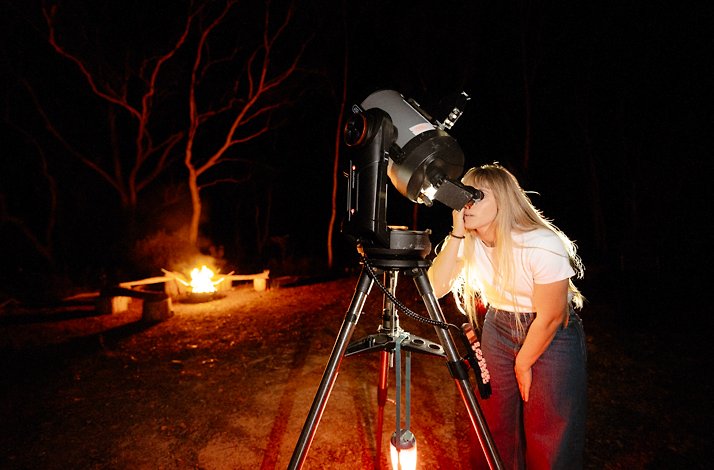 A woman stargazing with telescopes in the Blue Mountains, UNESCO World Heritage Site.