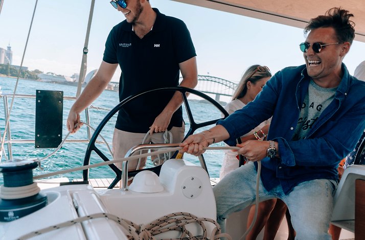 People laughing in a private yacht sailing across Sydney Harbour.