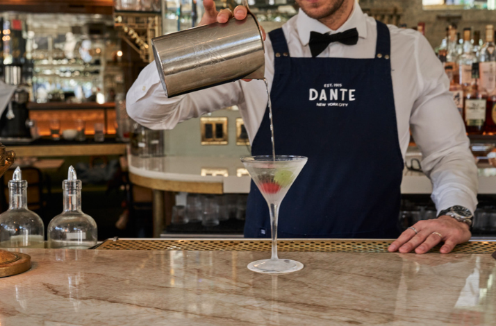 Bartender pouring a drink at the iconic Caffe Dante.