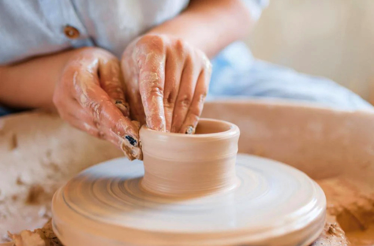The art of pottery making with Jamaican artisans, specifically the technique known as wheel throwing.