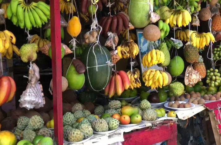 Colorful Jamaican market stall with bananas, tropical fruits, and fresh produce.