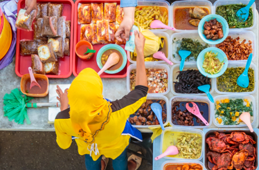 A shot from above of a woman selling herbs at a market stall