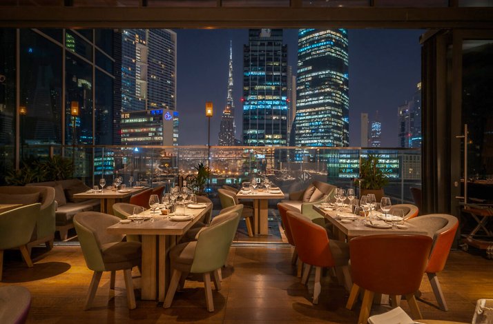 Tables with a view of the night city from CLAP Dubai.