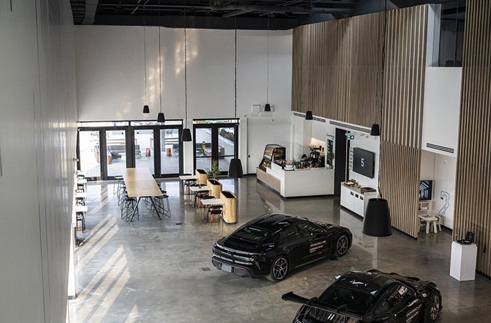 View over Porsche Experience Centre Toronto lounge with Porsche cars on exposition.