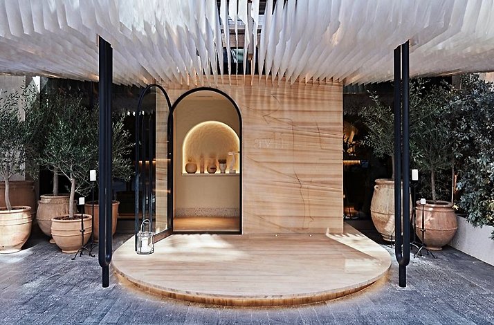 The stylish wood themed furniture at Greek Restaurant Avli by tashas, featuring greenery.