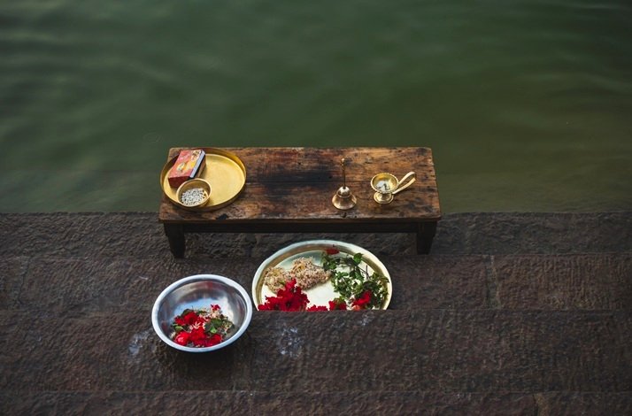 A table set with various dishes of food and glasses of water, ready for a meal.