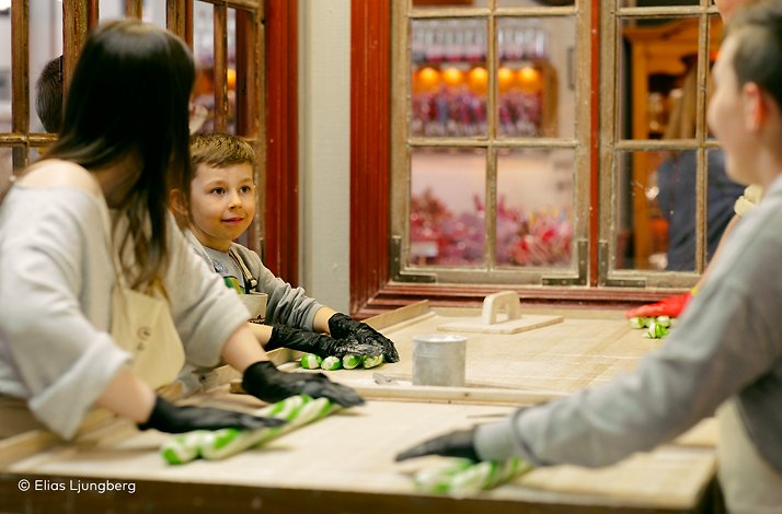 A family participating in a holiday candy-making workshop. ©Elias Ljunberg