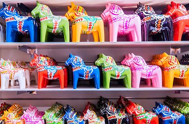 Shelves filled with vibrant, colorful, traditional Dala horses.
