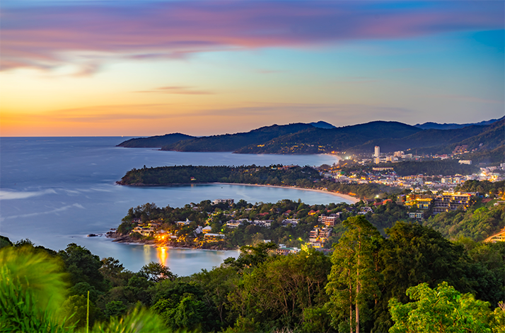 Scenic coastal view of Phuket at sunset with lush greenery.