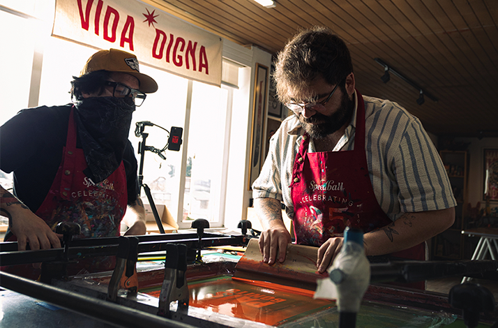 Tavo Garavato and Nicocina showing the basics of silkscreen printing.