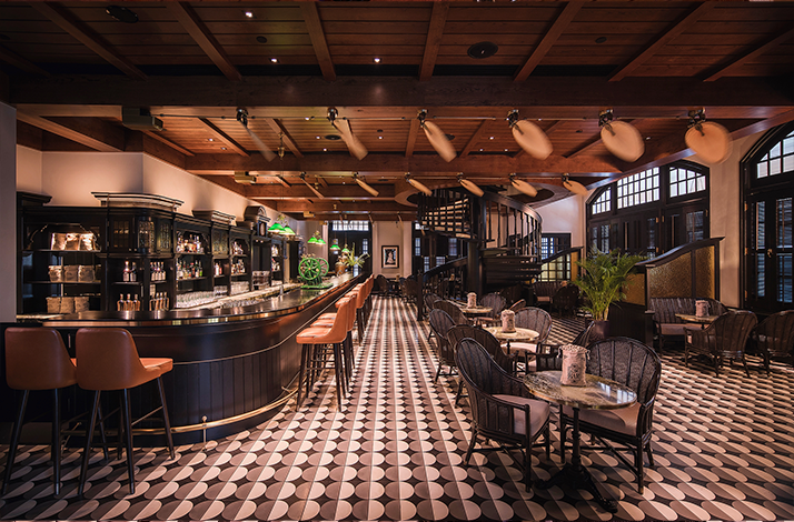 Hotel bar with wooden ceiling, leather stools, and patterned tile floorHotel bar with wooden ceiling, leather stools, and patterned tile floor