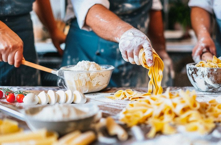 A group of individuals making pasta from scratch
